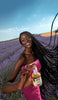 Model in field of lavender holding hair perfume